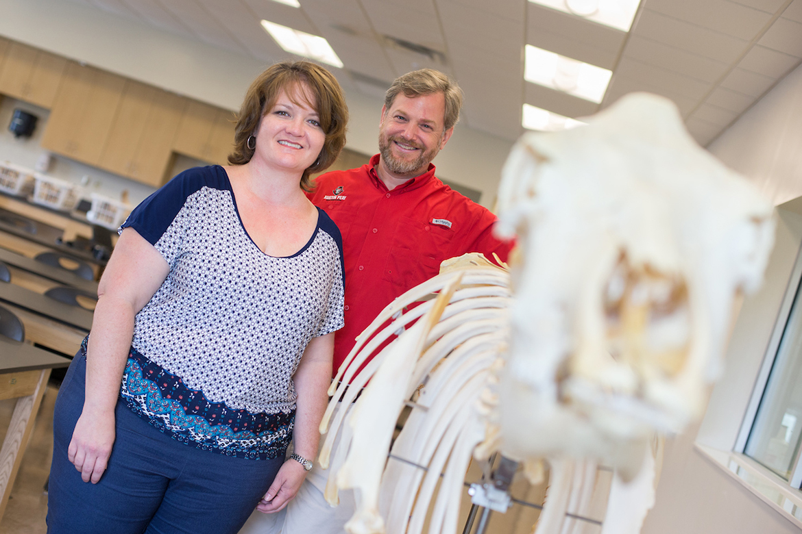 two professors with a cow skeleton