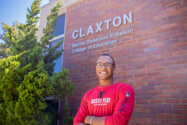 Student poses in front of Claxton Building 