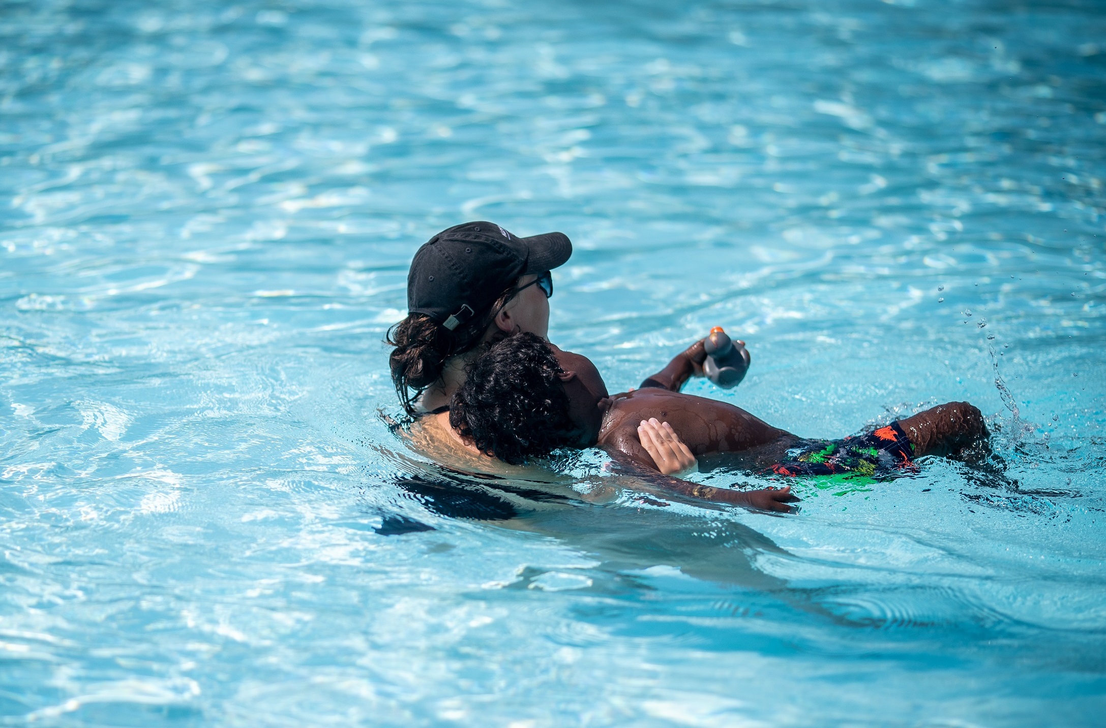 swim instructor teaching child to float on back
