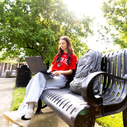 Student working on her laptop on campus