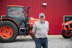 Man standing in front of farm equipment