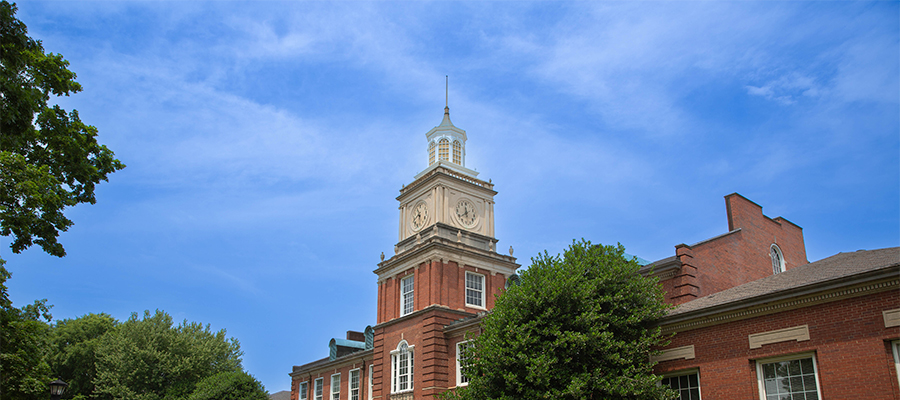 View of the Browning Building clock tower set against a blue sunny sky