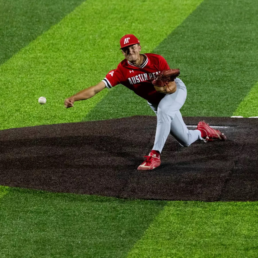 Baseball player throwing out a pitch from the mound.