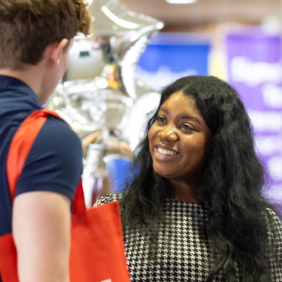 A student talking to a coach at a career fair.
