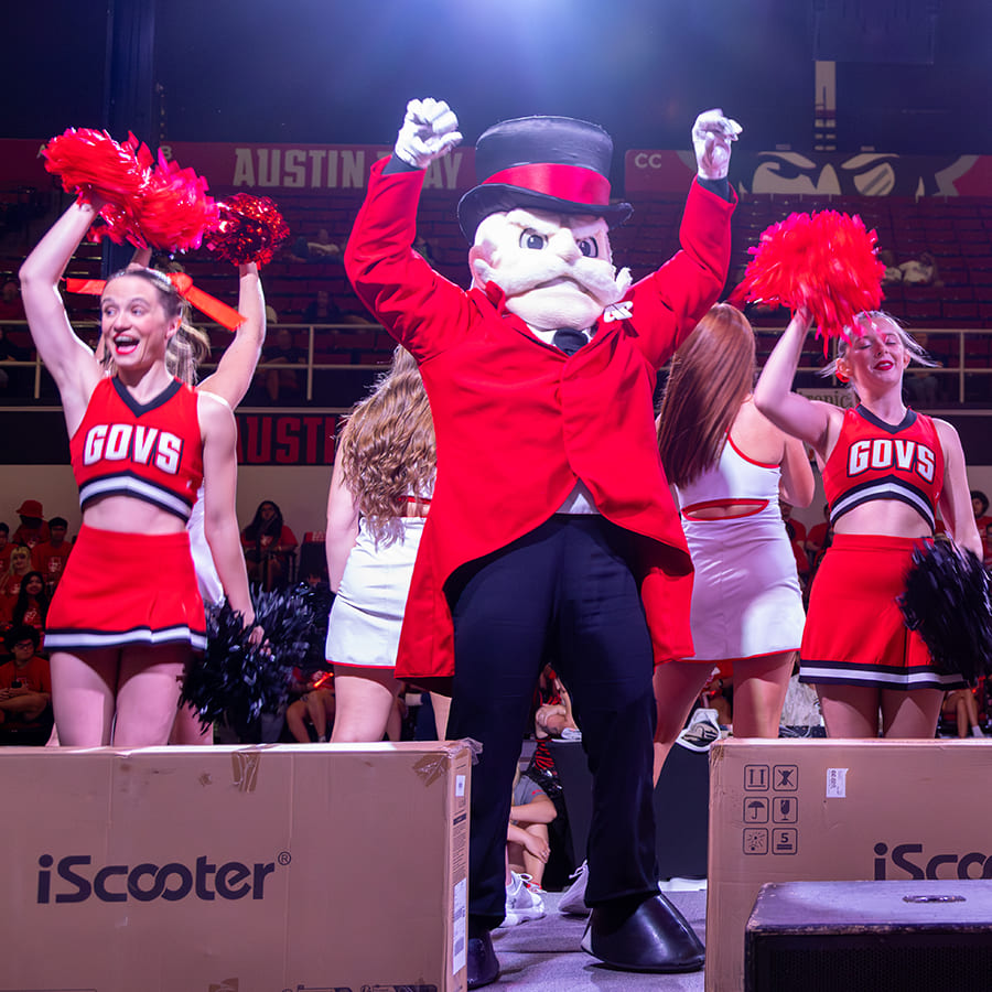 The Governor mascot with APSU cheerleaders and dancers on stage hyping up the crowd during a new student convocation.