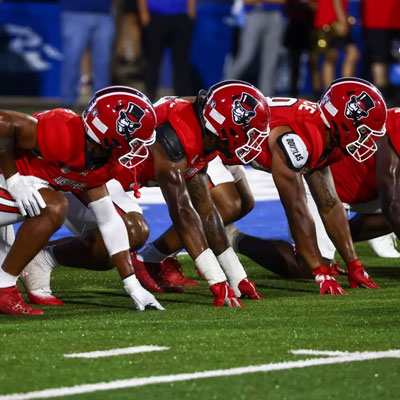 Football players lined up on the line of scrimage. 