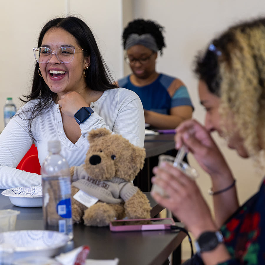 Students hanging out, enjoying snacks and laughing with each other.