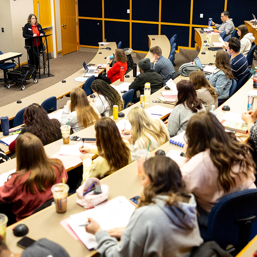 An audience of students listening to a speaker.