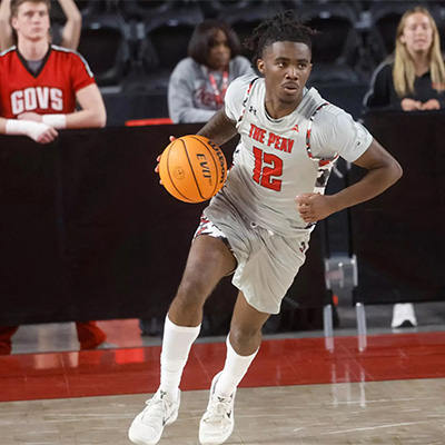 AP Basketball player dribbling down the court during a game.
