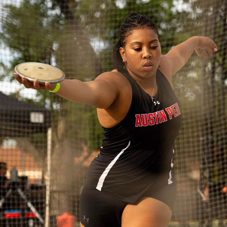 Female student athlete throwing a discus.