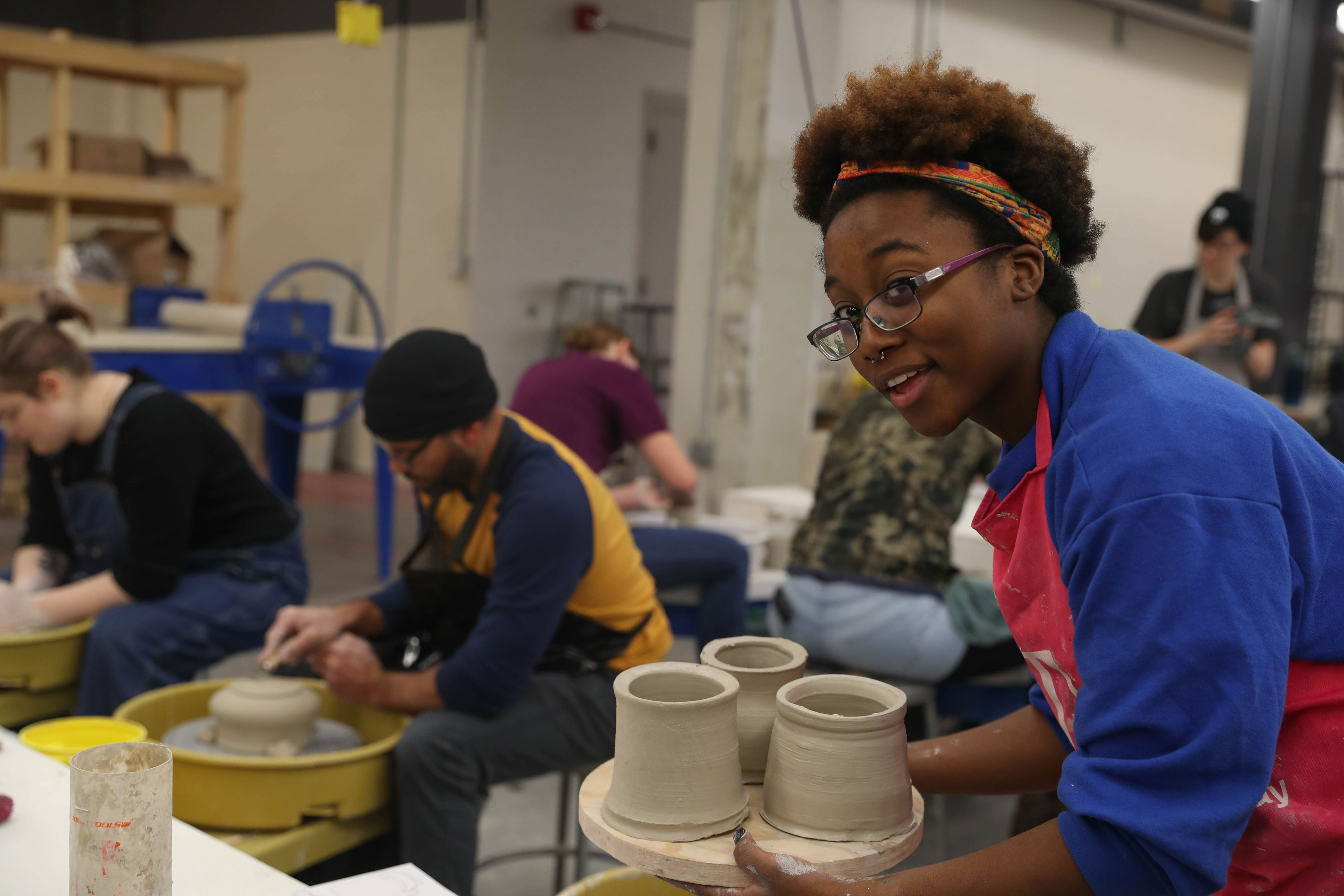 student in art studio with clay