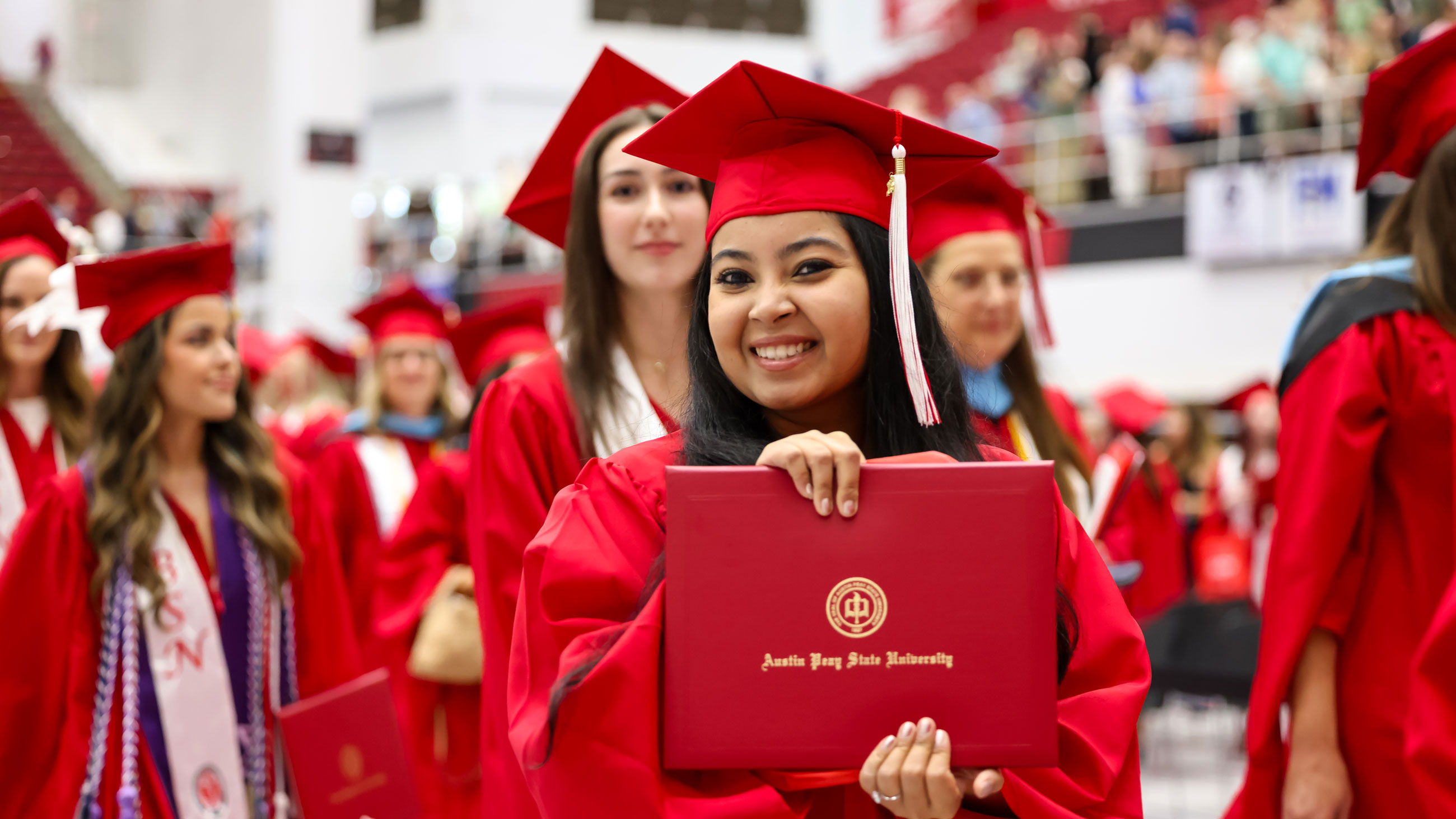 Student holding up their diploma at graduation