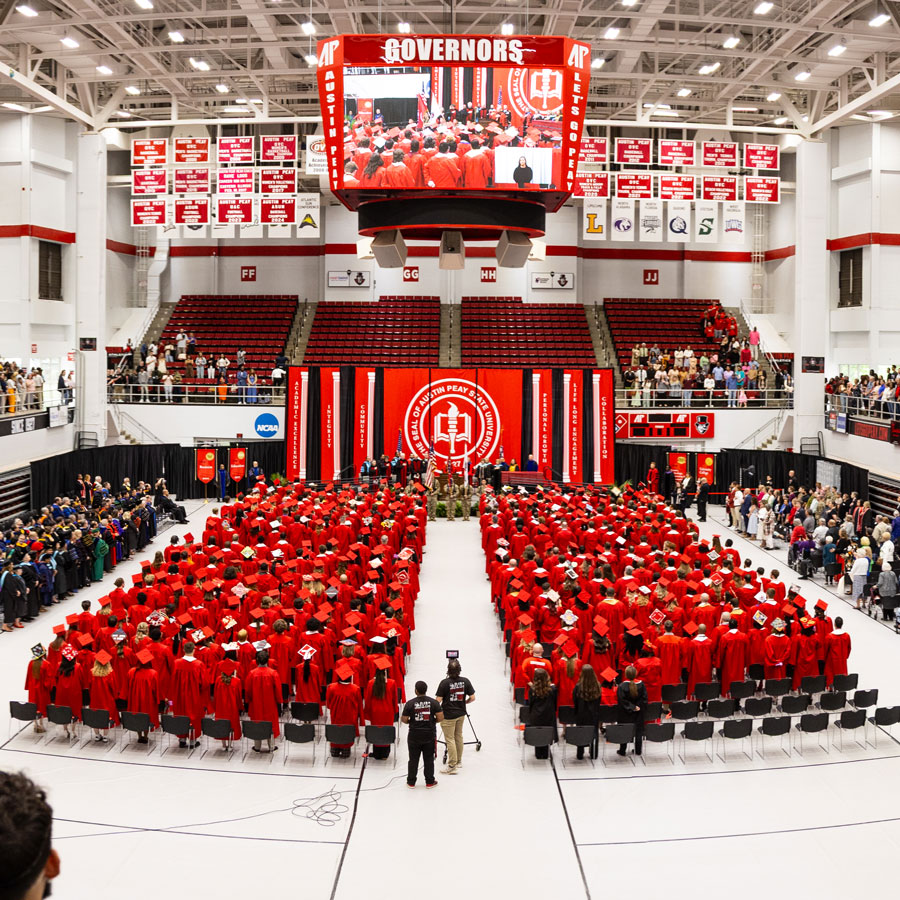 Extra wide shot of the commencement ceremony showing all the graduates sitting in their seat looking forward at the stage. 