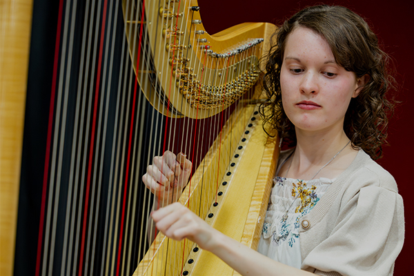 Student playing the harp.