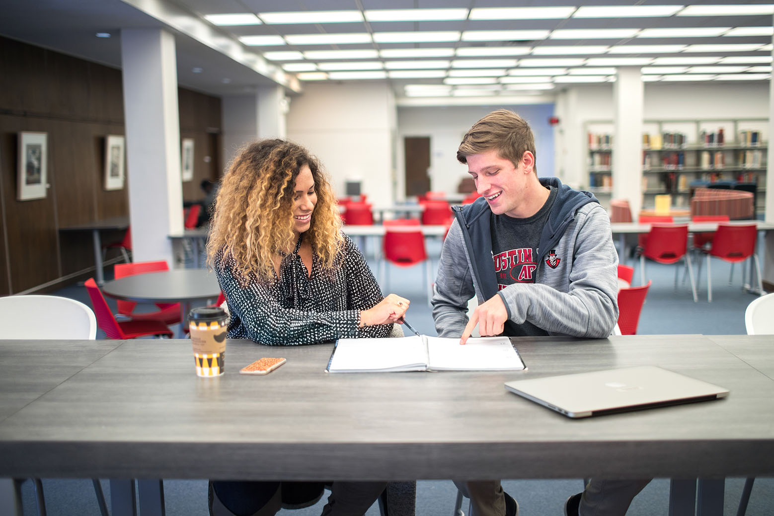 Students sitting at a table in the library studying for their exams. 