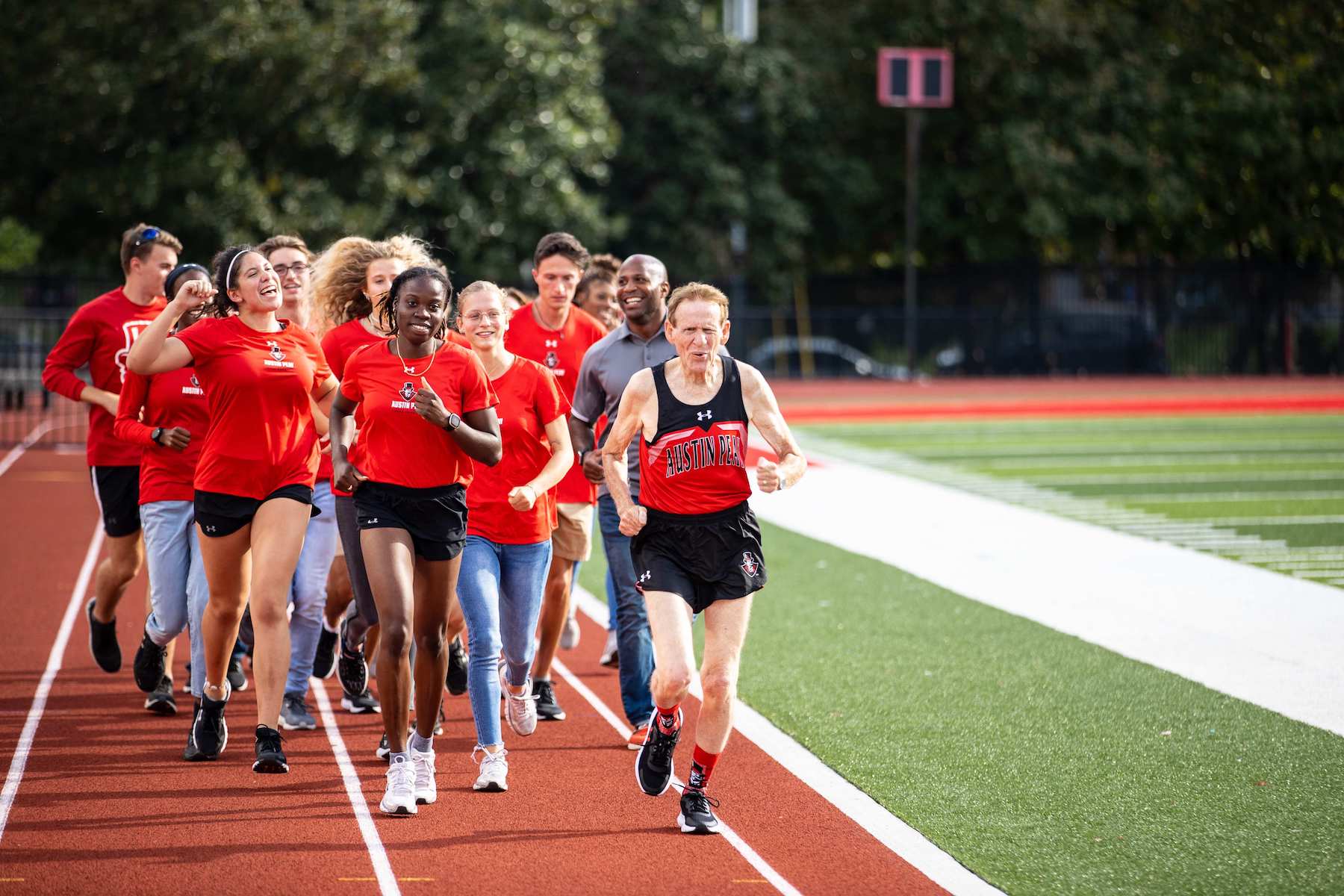 Cheered on by the APSU Track team, Ron Morton (’70), far right, breezes through a lap on the newly named Ron and Andrea Morton Track in Fortera Stadium to commemorate the new track’s ribbon-cutting ceremony on Friday, Sept. 9. Since he had been used to running on a subpar surface during his time on the track team in the ‘60s, Morton wanted to celebrate the state-of-the-art track by experiencing it himself.  Sean McCully | University Photography and Videography Coordinator 