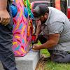 Bolting the sculpture to the concrete foundation.