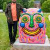 The artist with their completed work on campus.