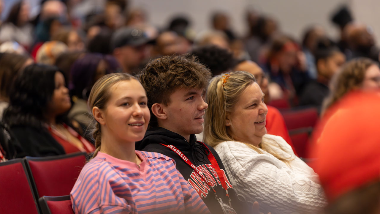 Picture of an auditorium full on Govs Preview with the focus on a family. 
