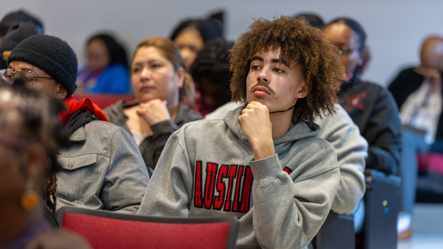 Student sitting in an auditorium listening to a presentation.