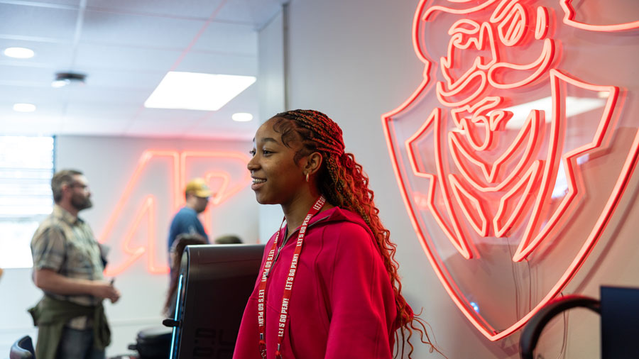 Student in the Education Tech room explaining what students can expect. 