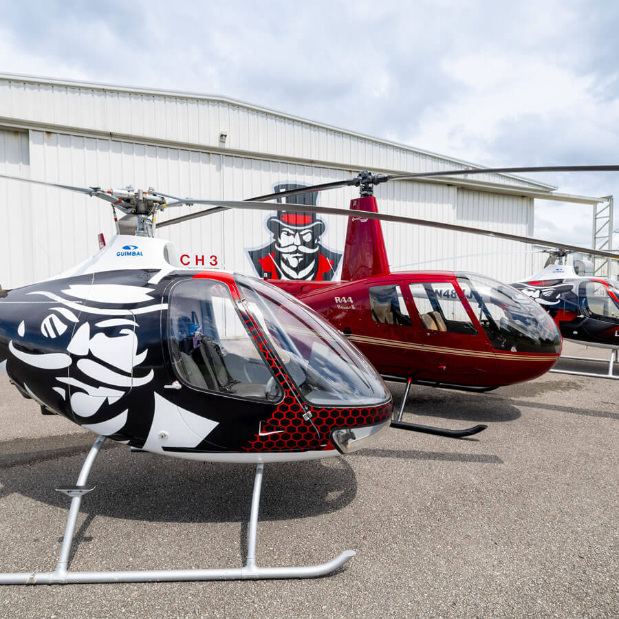 3 of APSU's helicopters sitting infront of the hangar at Outlaw Field.