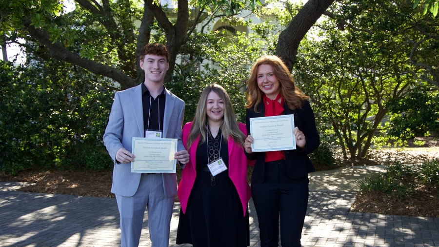 Zack Allen and Zoeigh Owens posing with Dr. Stephanie Bilderback with their Student Research Awards