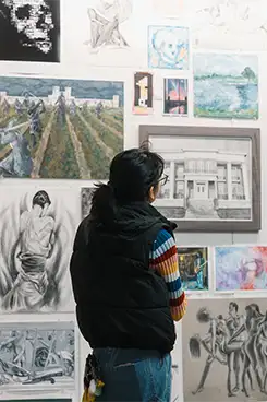 Student looking at the art displayed in a gallery.