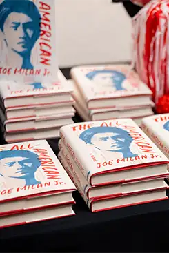 Stack of books sitting on a table at a book signing event