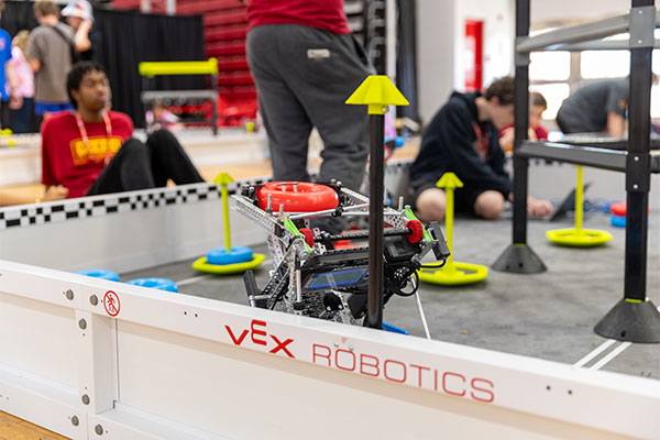 Robot moving a ring inside the VEX arena.