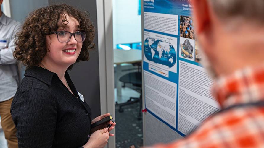 An APSU presents a research poster during a symposium event on campus.