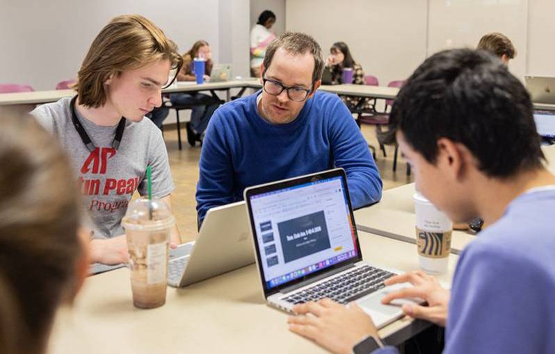 Dr. Zack Barnes works with students in a classroom setting.