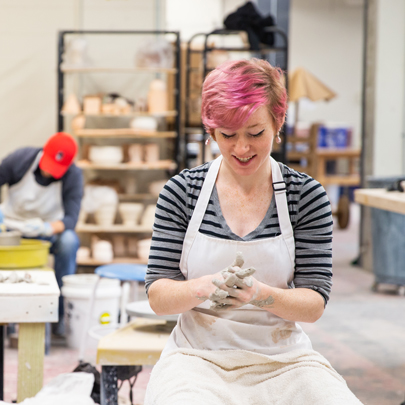 Ceramics student with clay on their hands