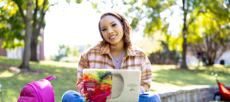 Student sitting outside by the Harned Bowl