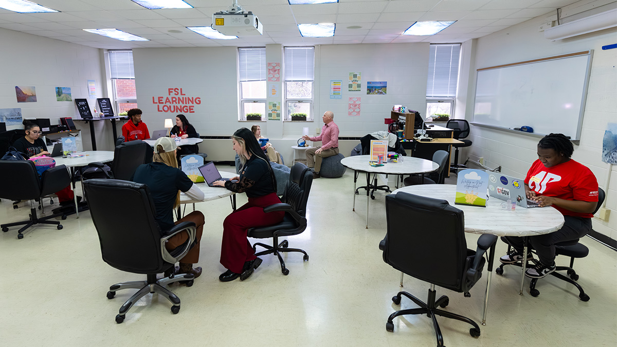 A panoramic photo of the FSL Learning Lounge area with students and staff sitting at tables.