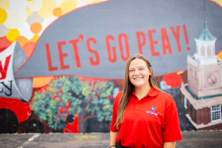 Alex Edwards in front of the Let's Go Peay! mural.