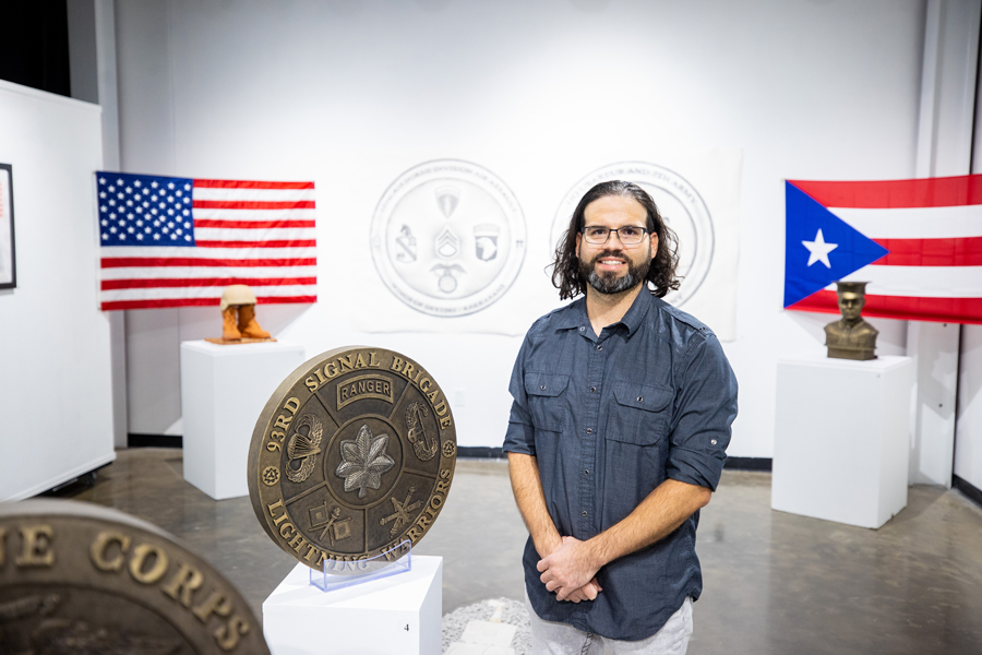 Carlos Carpena standing next to one of his Challenge Coin Exhibits