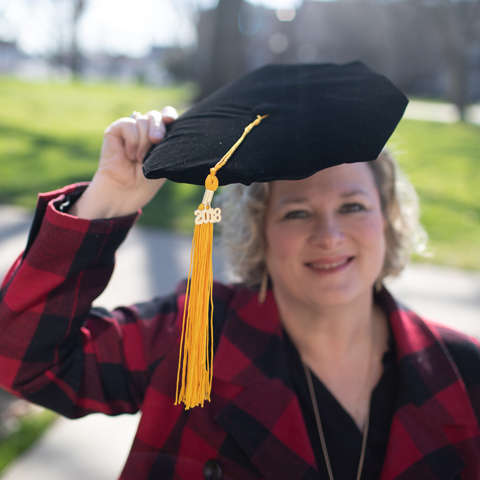 Sarah Dugger holding her grad hat