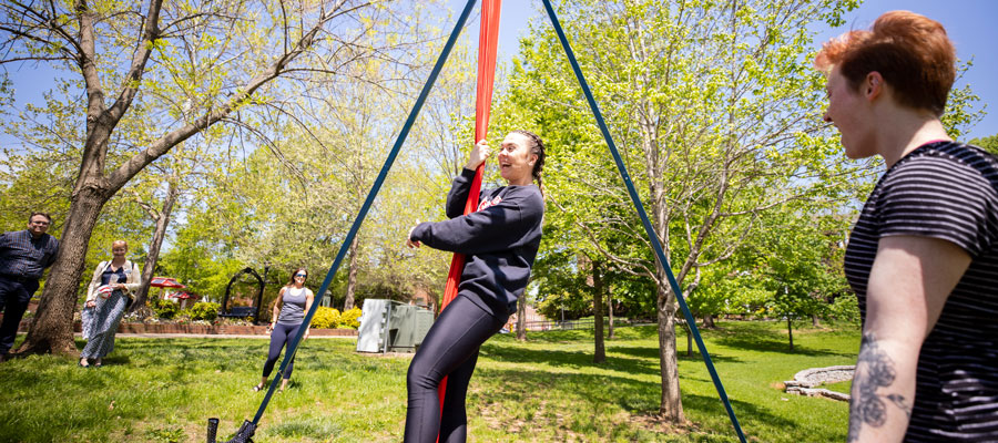 Student trying out aerial silks at a public demo on campus.