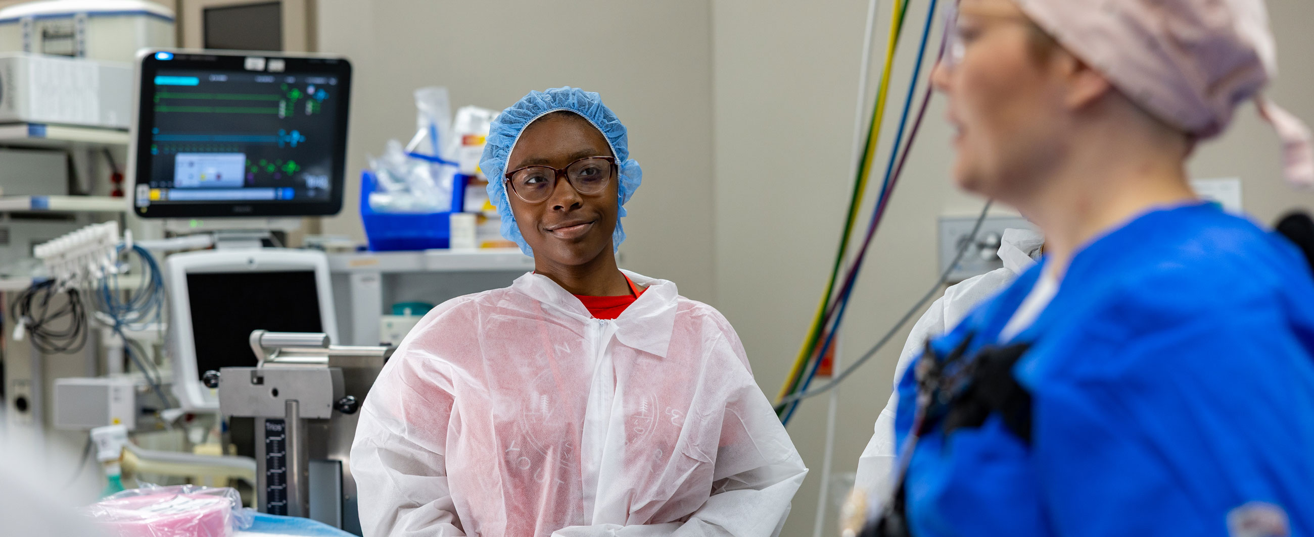 Nursing student listening to the instructor during a simulation.