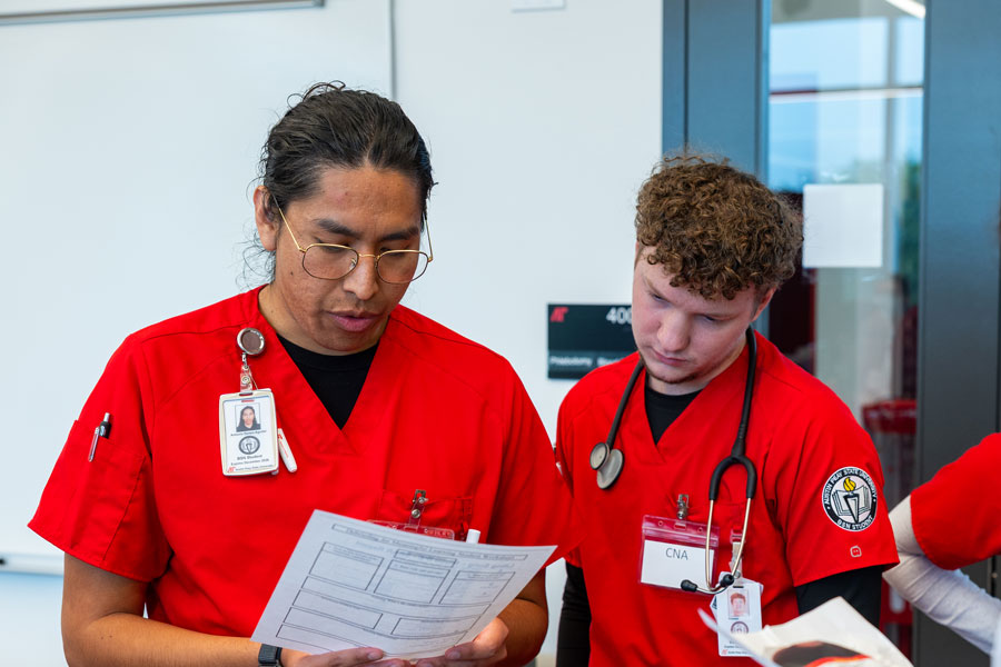 Two nursing students looking at their assignment sheet.