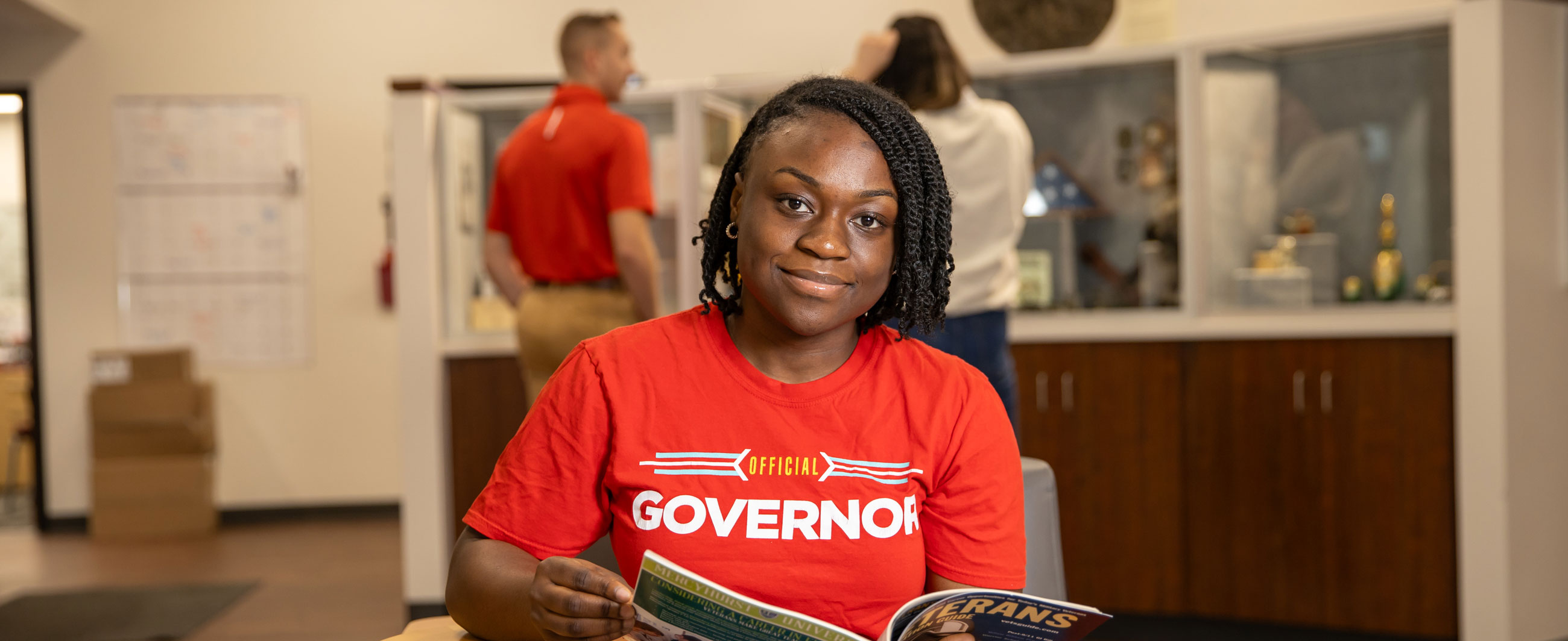 Student sitting in the lobby reading a magazine