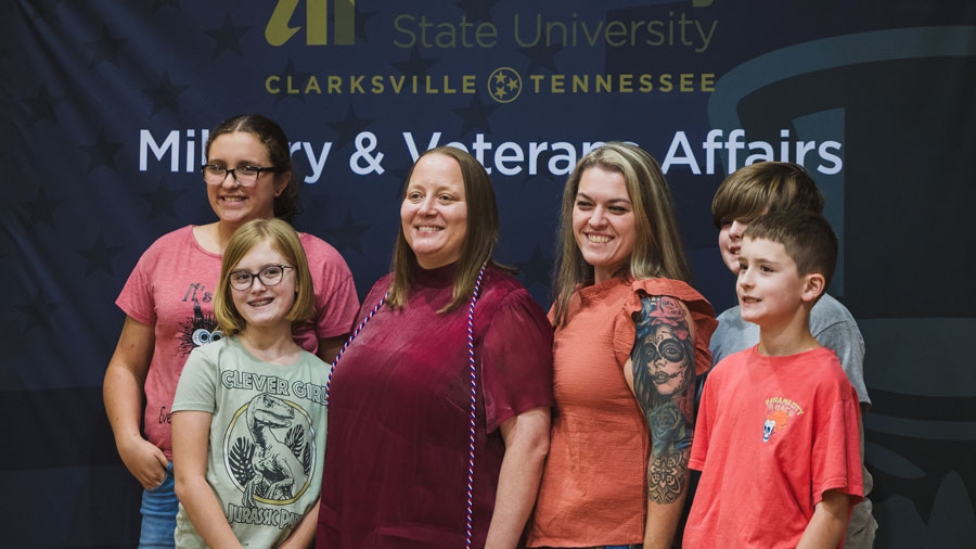 Veteran graduate with their family posing for a group photo