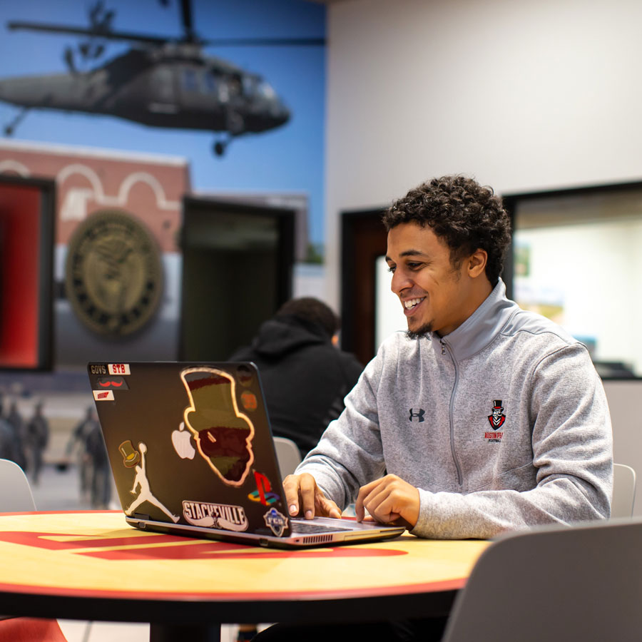 Student working on a laptop inside the Newton Center