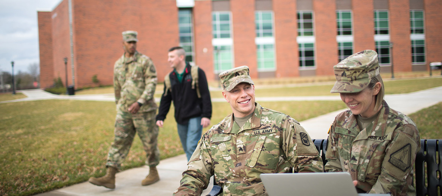 military students talking outside on a bench
