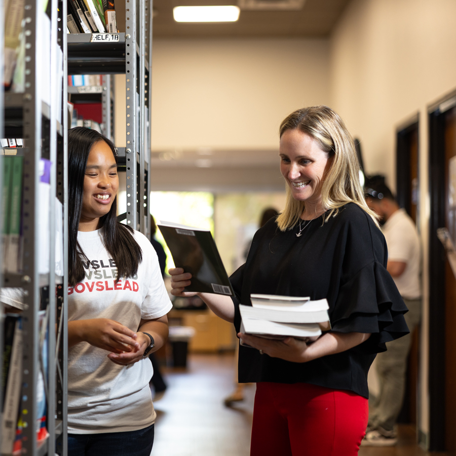 Student getting help gathering their textbooks for class