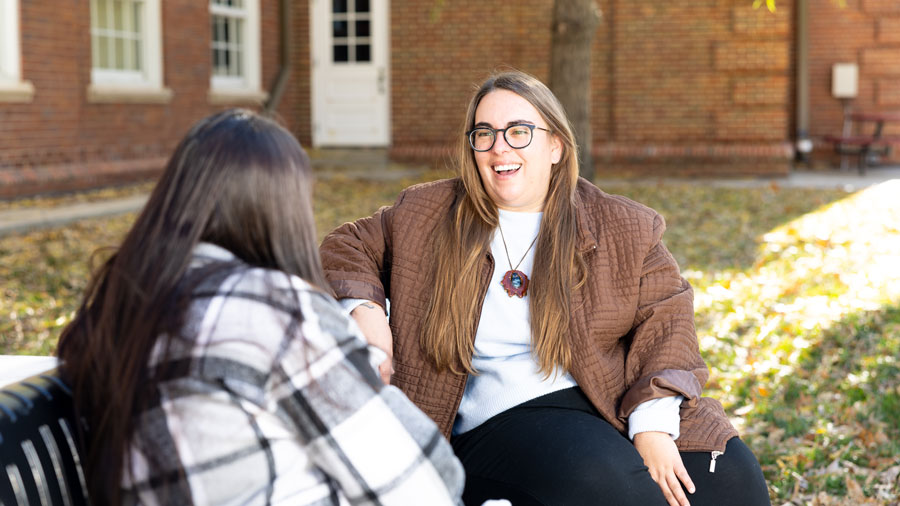 Student and counselor talking on a bench