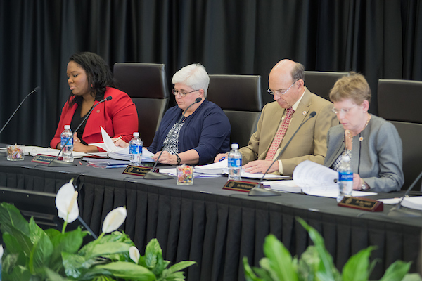 APSU board members review documents during a meetin