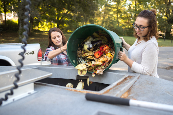Two APSU employees dump food waste into the University's new composter.