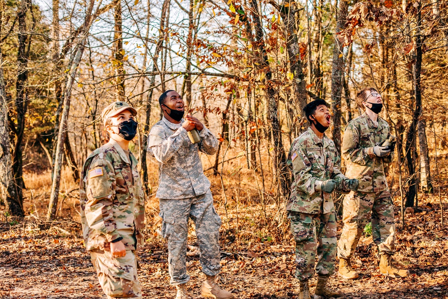 Senior cadet Chantal Alequin and three underclassmen cadets cheer another Army ROTC cadet on at the Air Assault School obstacle course.